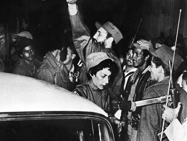 El l&iacute;der rebelde cubano Fidel Castro (en el centro) junto a su secretaria Celia S&aacute;nchez Manduley y miembros de la guerrilla 'Movimiento 26 de Julio' a su entrada en Cienfuegos el 4 de julio de 1959.