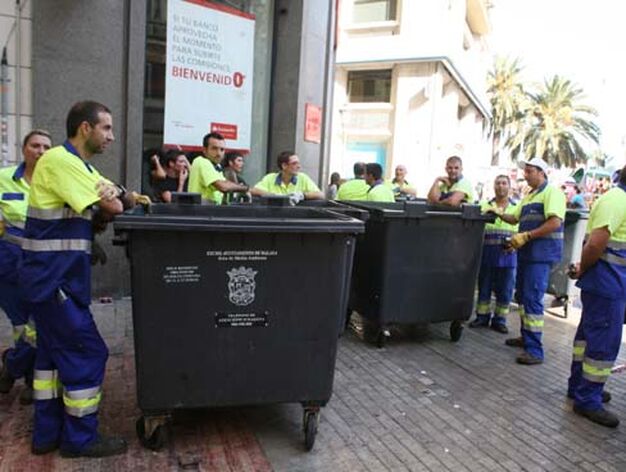 Trabajadores de la limpieza esperan para recojer la basura.