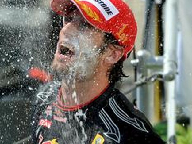 Alonso ba&ntilde;a en champagne a Webber. / EFE