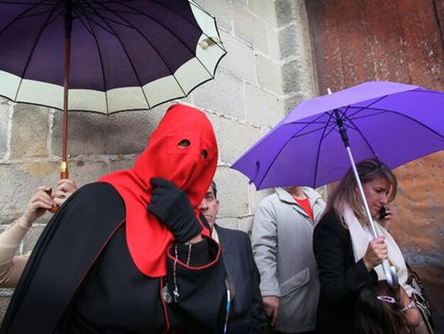 Un nazareno de Los Jud&iacute;os pasa bajo un paraguas en las inmediaciones de la iglesia de San Mateo.

Foto: Miguel &Aacute;ngel Gonz&aacute;lez