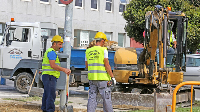 Una imagen de dos trabajadores de la construcción en plena faena, en una calle de Jerez.