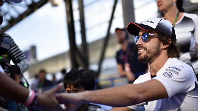 Fernando Alonso saluda a un aficionado durante el Gran Premio de Japón.