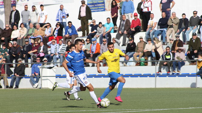El central azulino Antonio conduce la pelota perseguido por un jugador del conjunto conileño.