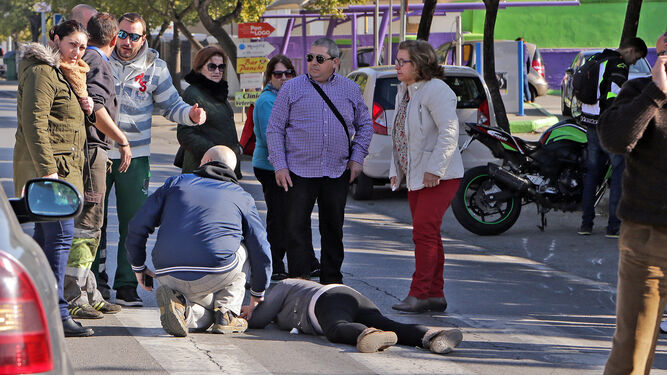 La mujer permanece ayer inmovilizada sobre el asfalto. A la derecha, la moto.