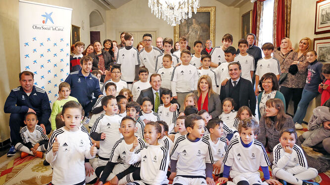 Emilio Butragueño, sonriente rodeado de los alumnos de la Escuela de la Fundación Real Madrid ayer en el Salón Noble del Ayuntamiento.