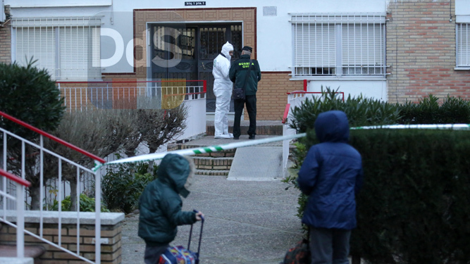 Dos niños observan a los agentes de la Guardia Civil a las puertas del domicilio del crimen.