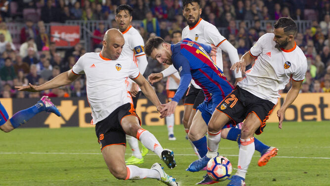 Messi trata de salir de la presión de tres rivales.