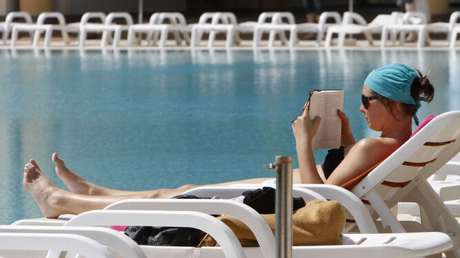 Una turista disfruta del buen tiempo en un hotel de Chiclana la pasada Semana Santa.