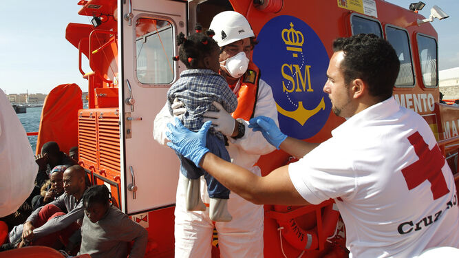 Dos efectivos de la Cruz Roja ayudan a desembarcar a una niña, ayer en el puerto de Tarifa.
