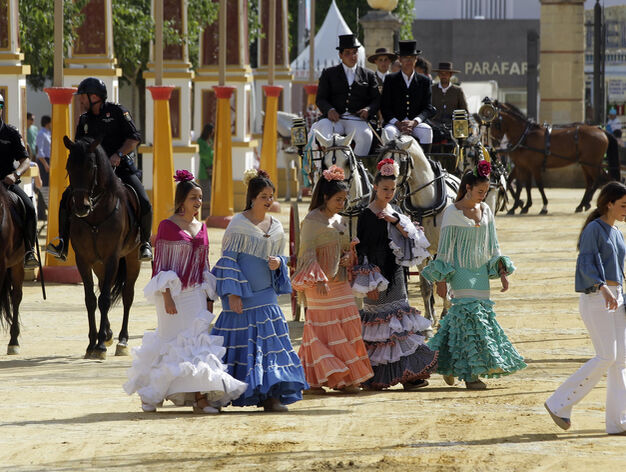 Un grupo de j&oacute;venes ataviadas con sus trajes de flamencas pasean por el Real de la Feria