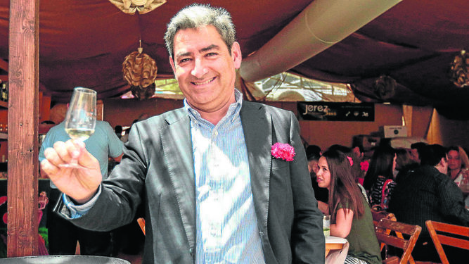 Juan Baquero alza su catavino durante una visita a la caseta de los empresarios de Adecosur.