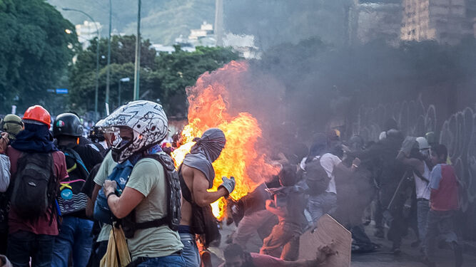 El joven Orlando José Figueroa es alcanzado por las llamas durante una manifestación opositora el sábado en Caracas.