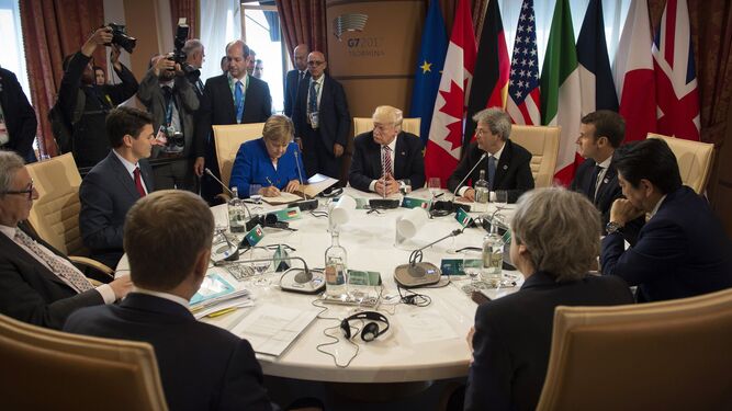 La canciller Angela Merkel -a su izquierda, Donald Trump-, firma la declaración contra el terrorismo ante la mirada del resto de líderes de G7.