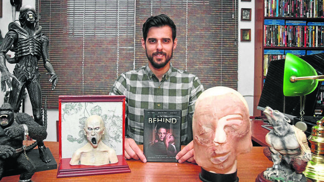 El algecireño Ángel Gómez, en su casa con la portada de 'Behind' en sus manos y las caretas de terror usadas en diferentes proyectos.