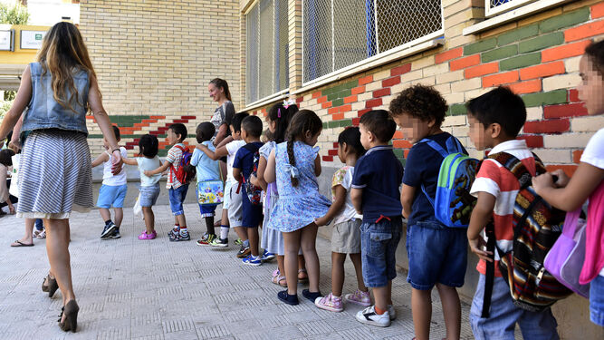 Varios niños guardan la fila en un colegio de Sevilla capital.