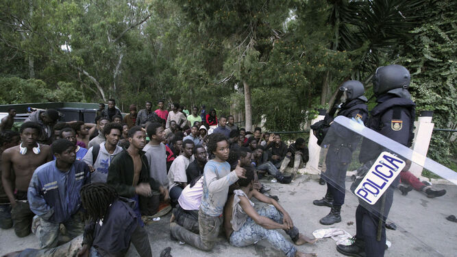 Inmigrantes custodiados por la Policía tras traspasar la valla de Ceuta.