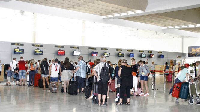 Viajeros esperan en la cola de los mostradores de facturación en una terminal aeroportuaria más concurrida que nunca por estas fechas.
