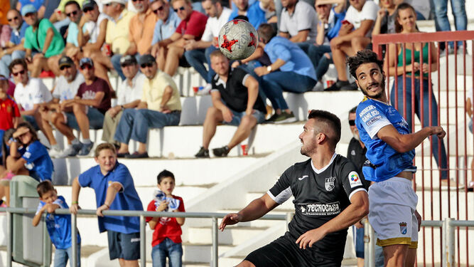 Guerrero salta junto a un futbolista del Alcalá para intentar despejar el balón de cabeza.