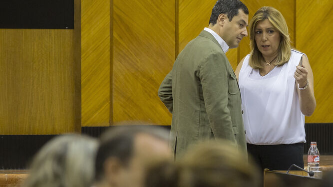 El líder del PP-A, Juanma Moreno, y la presidenta de la Junta, Susana Díaz, conversan en un Pleno del Parlamento.