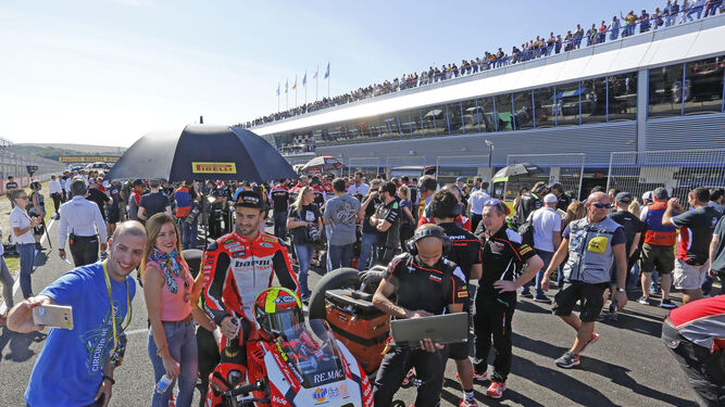 Un aficionado se hace una foto con el español Xavi Forés momentos antes de la salida de la carrera de Superbikes.