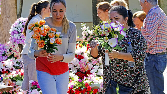 Una joven acaba de adquirir unas flores en el Cementerio.