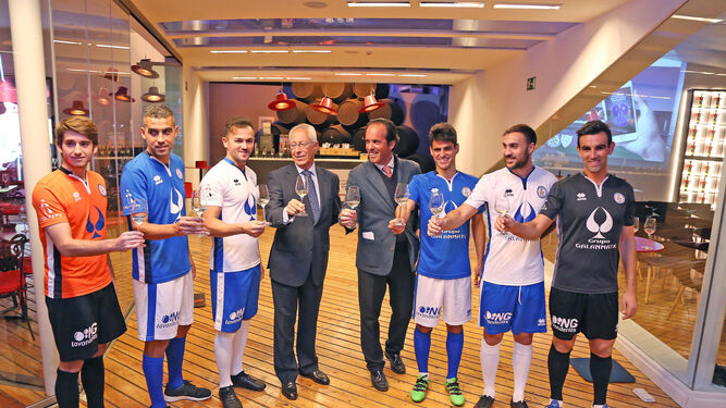 José Argudo y Rafael Coca posan con una copa de Tío Pepe junto a los futbolistas que acudieron al acto.