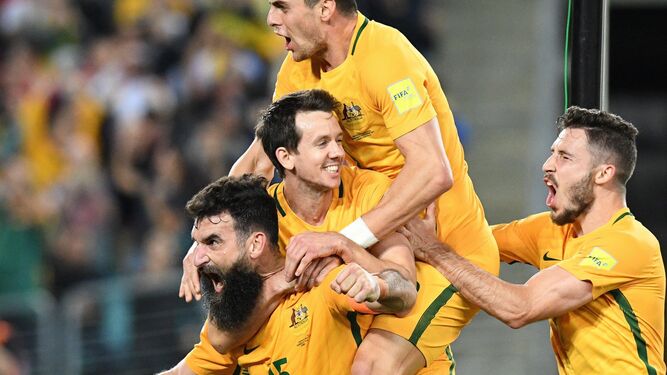 Los futbolistas australianos se suben encima del barbudo Jedinak.