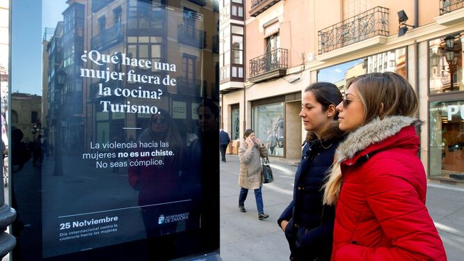 Dos mujeres observan uno de los carteles de la campaña contra la violencia machista del Ayuntamiento de Zamora.