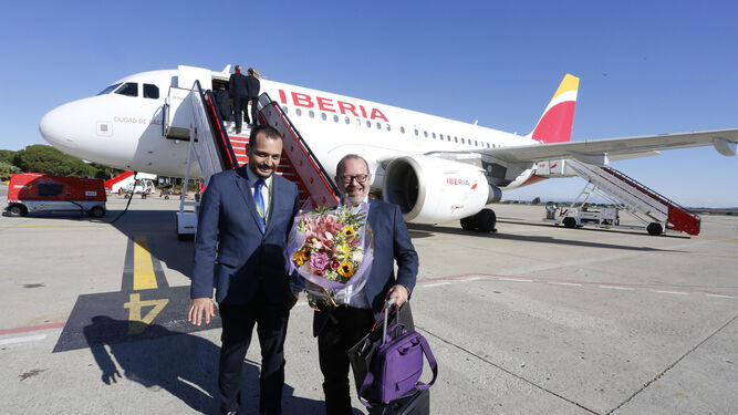 El director del aeropuerto, Iván Rodríguez, entrega ayer un ramo de flores al pasajero Ángel Pereira, acompañado por la tripulación del vuelo.