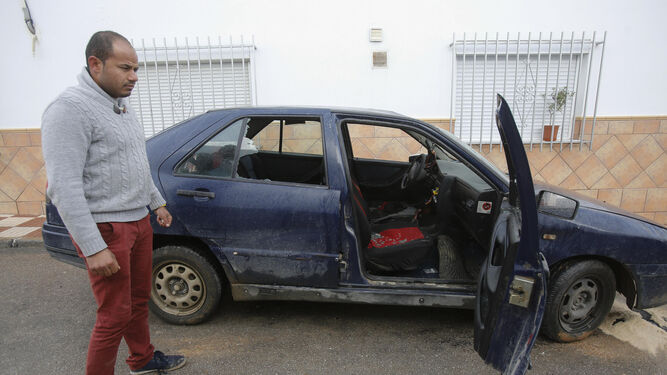 Un ciudadanos rumano muestra el estado en el que ha quedado su coche tras los altercados