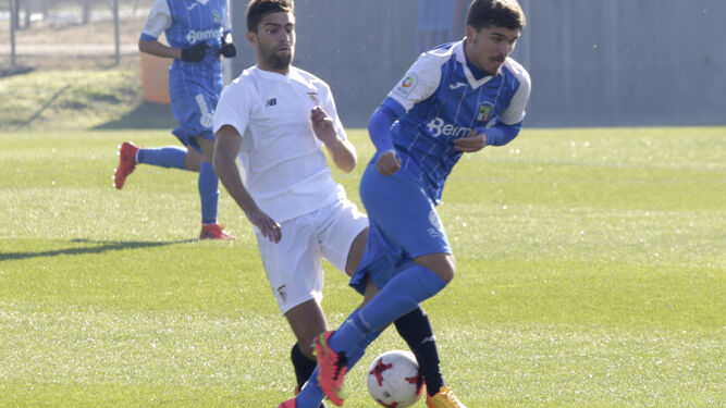 Pablo se intenta llevar el balón pese a la oposición de un futbolista del Sevilla C.