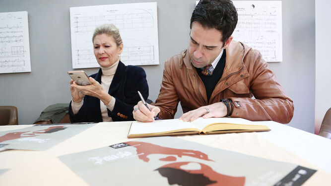 Ismael Jordi e Isabel Rey firman en el libro de honor del Diario.