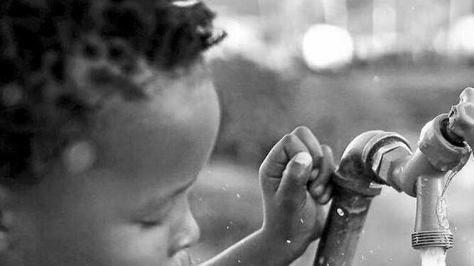 Un niño sudafricano bebe agua de una fuente, en una imagen de archivo.
