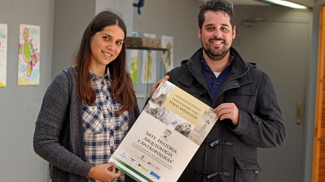 Mercedes Sánchez y Pablo González, miembros del comité organizador, con el cartel de las jornadas.