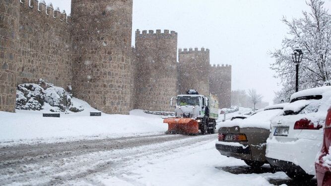 Una maquina quitanieves trabaja para retirar la nieve junto a la muralla de Ávila.