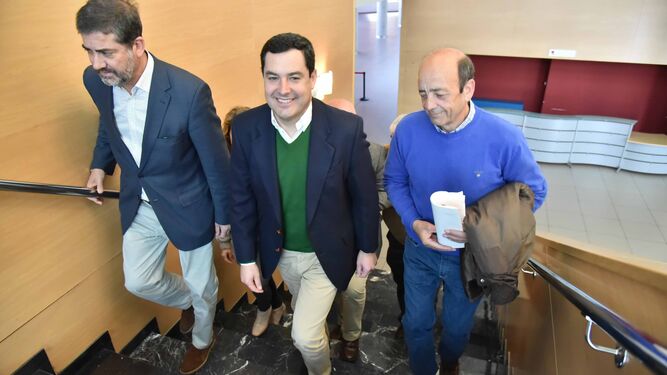 Juanma Moreno, en el centro y con Pablo Arriaga a su izquierda, a su llegada al Palacio de Congresos de La Línea, ayer.