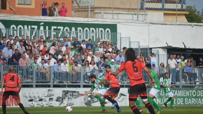 Alberto García cae tras la entrada de un rival ante la nueva grada de General repleta de aficionados.