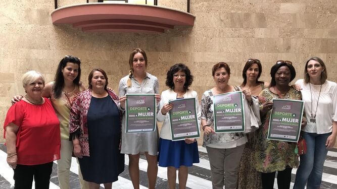 Representantes de la federación La Voz de las Mujeres, en el Ayuntamiento con el cartel de las jornadas.