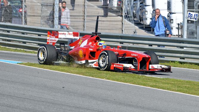 Un Ferrari pisa el verde entrando en boxes durante unos entrenamientos de F1 en Jerez.