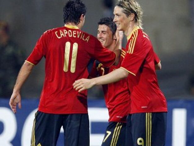 Capdevila y Torres felicitan a Villa por su primer gol.