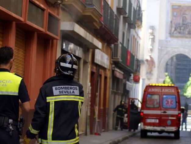 Un bombero y un polic&iacute;a observan el humo que sale de la parte trasera del restaurante.

Foto: Marisa Rivera