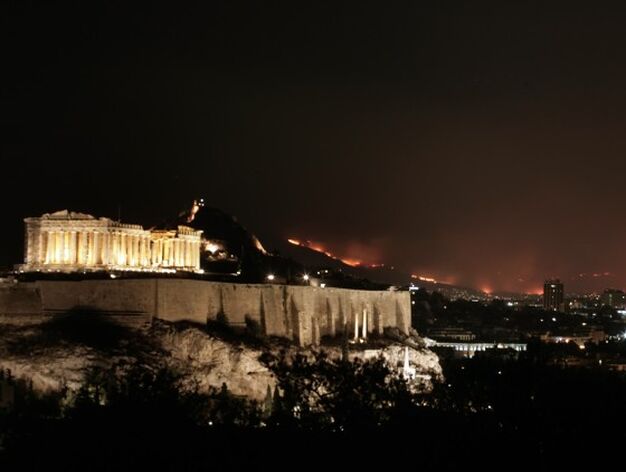 La Acr&oacute;polis en Atenas con las llamas del incendio como fondo, este ya est&aacute; a menos de 30 kil&oacute;metros de la capital Griega.

Foto: AFP