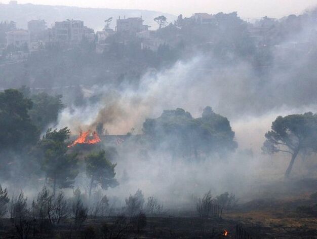Una casa queda rodeada por las llamas en la localidad de Drafi a 12 kil&oacute;metros de la capital griega.

Foto: Efe