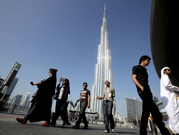 Un grupo de dubait&iacute;es pasea bajo la Burj Dubai. / Reuters