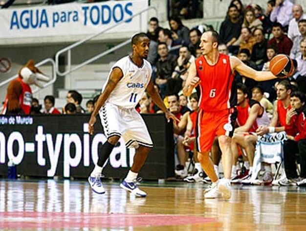 Pedro Robles (Murcia) controla el bal&oacute;n ante la defensa de Earl Calloway. 

Foto: ACB Photo / Javier Bernal