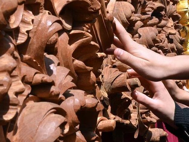 Tocar para ver. Manos de cofrades que no pueden reprimir tocar la madera a&uacute;n sin dorar del paso de misterio del Soberano Poder.

Foto: Manuel Aranda