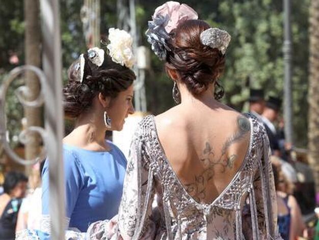 Una joven exhibe tatuaje y traje de flamenca por el Real.

Foto: Vanesa Lobo