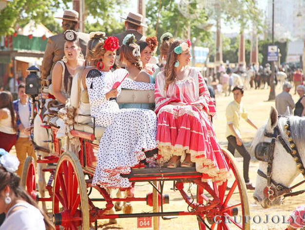 Un grupo de j&oacute;venes vestidas de flamenca paseando en un coche de caballos

Foto: Vanesa Lobo