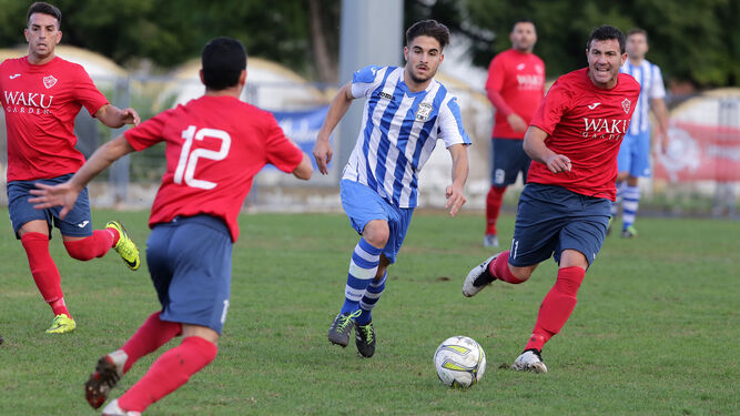 Mendoza y Quintero presionan a un futbolista guadiareño.