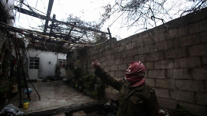 Un granjero señala los daños causados por los combates en su vivienda en Douma, zona controlada por los rebeldes.